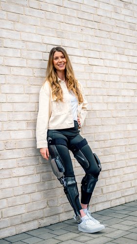 Eine zufriedene junge Frau mit der Ganzbeinorthese "C-Brace" der Firma Ottobock